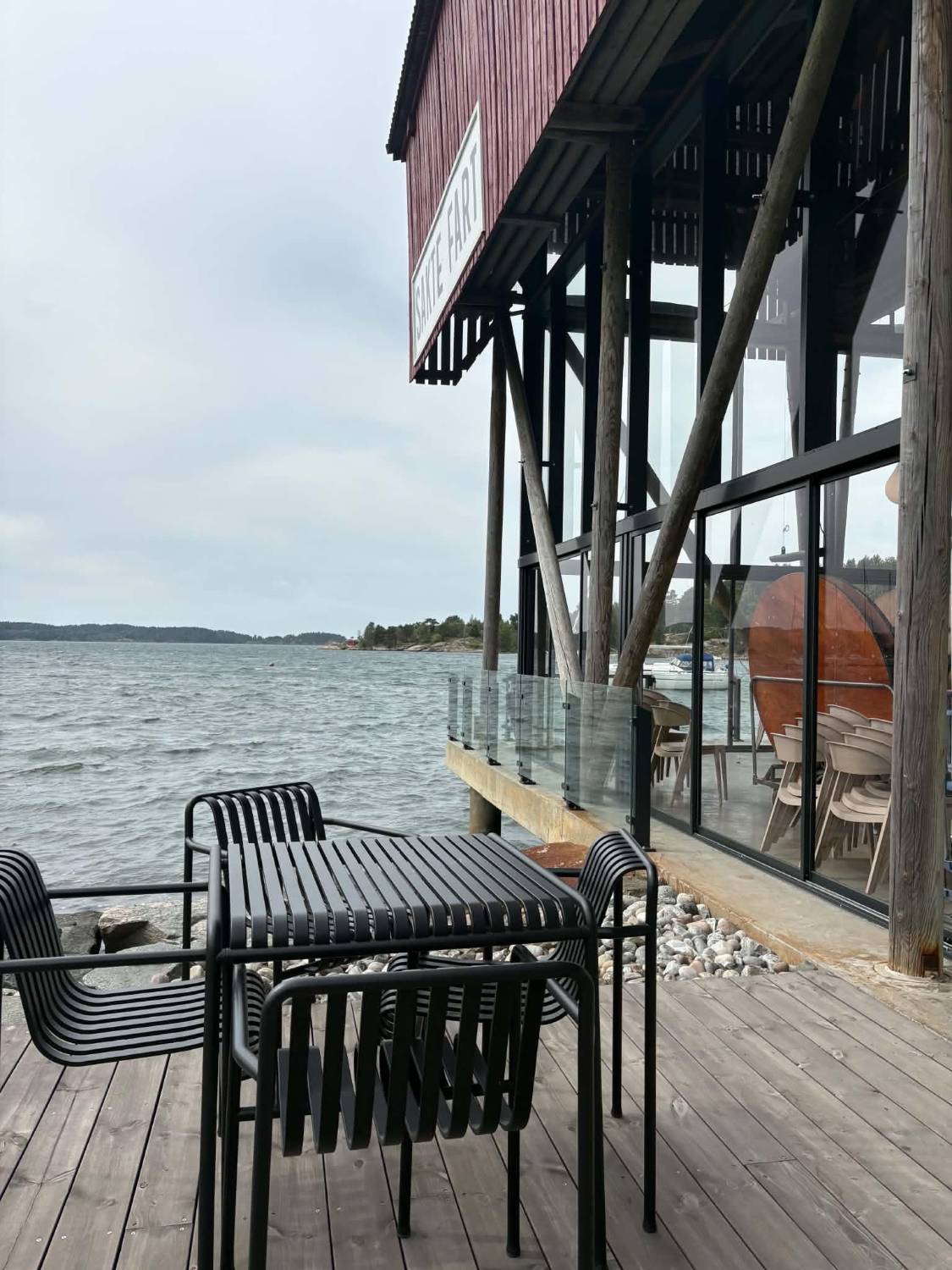 Bord og stoler på terrassen med utsikt over fjorden